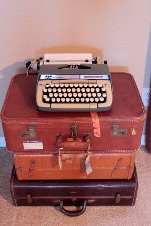 Vintage typewriter on a stack of vintage suitcases. Very cute, but everywhere.